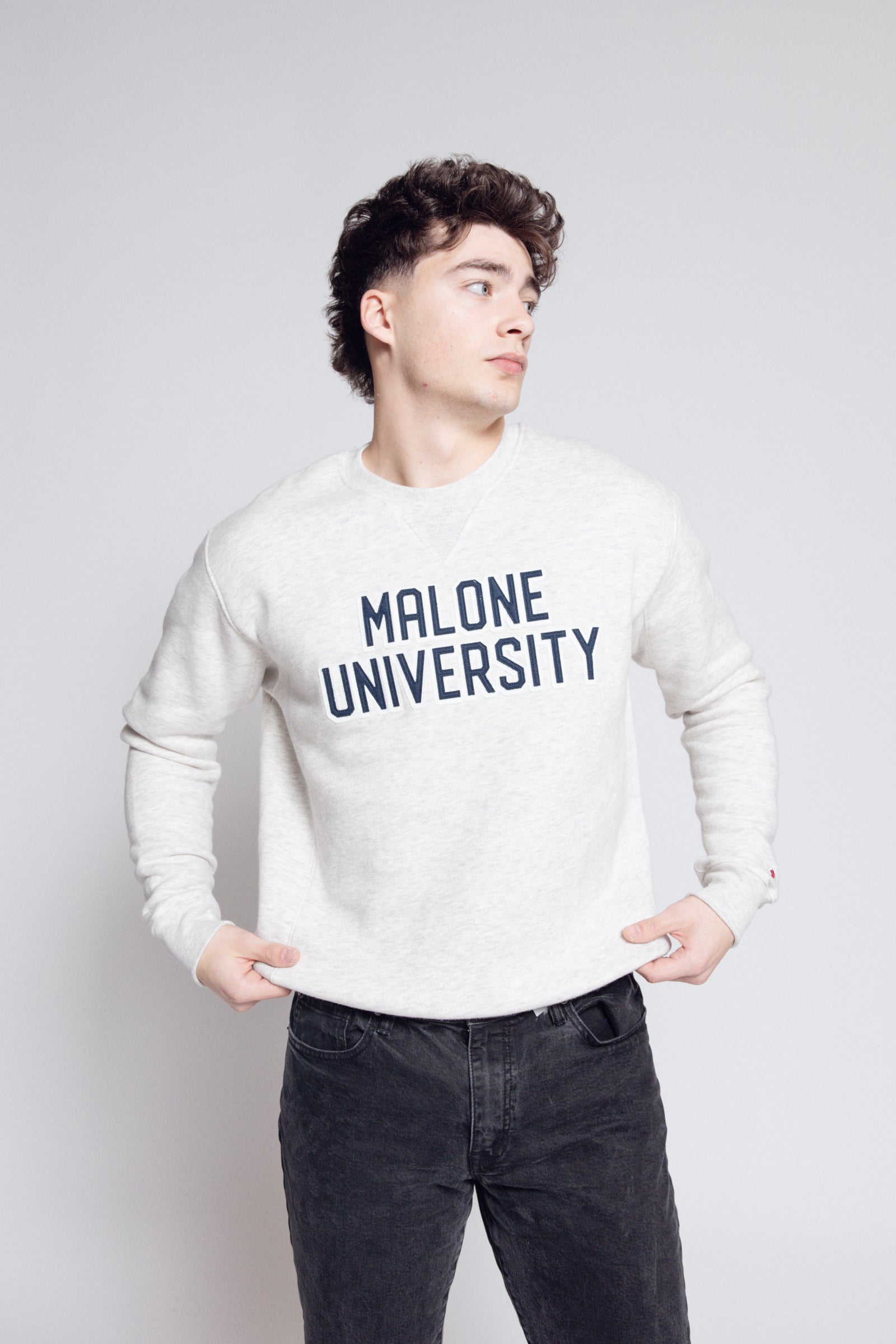 Man wearing 'Malone University' crew against gray background.
