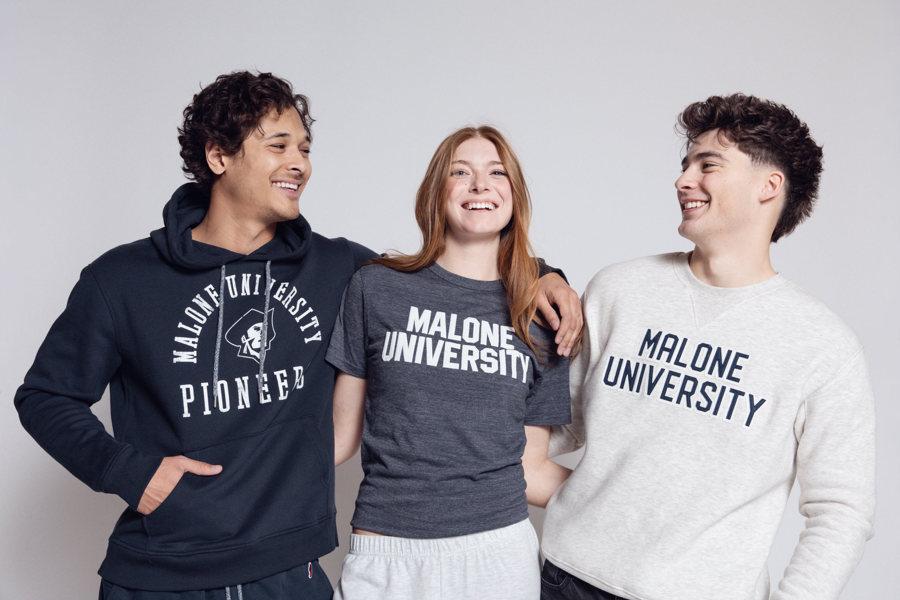 Group wearing Malone gear against gray background.