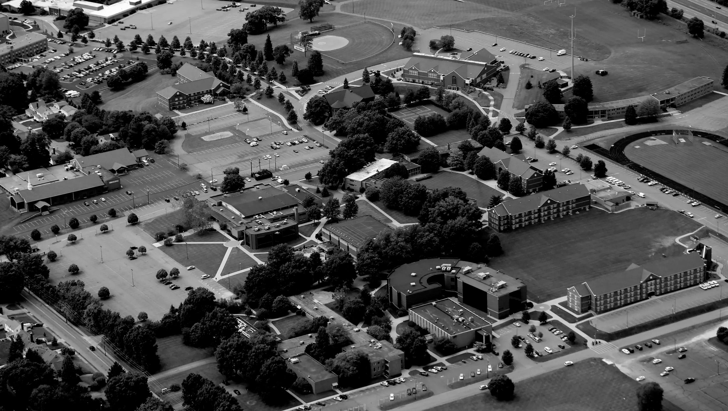 Aerial view of Malone campus with buildings, roads, and green spaces.